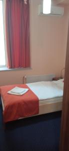um quarto com uma cama com um cobertor vermelho e uma janela em Penzion Gremium em Bratislava