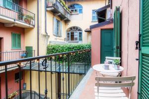 a balcony with a table and chairs and a green door at Silvia Como House - The House Of Travelers in Como