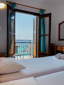a bedroom with a bed and a view of the ocean at Pansion Giannis Perris in Kokkari