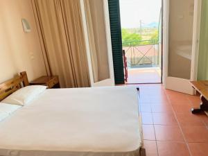 a bedroom with a bed and a view of a balcony at Klitemnistra Rooms in Mykines