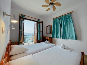 2 camas en una habitación con ventana en Pansion Giannis Perris, en Kokkari