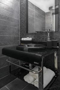 ein Badezimmer mit einem Waschbecken, einem Spiegel und Handtüchern in der Unterkunft WILLY-ANDON APARTMENT in Warna