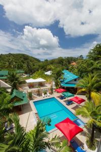 an aerial view of a resort with a pool and umbrellas at Patong Rai Rom Yen Resort SHA in Patong Beach