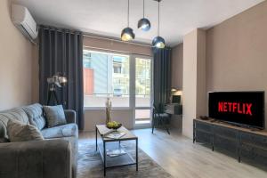 a living room with a couch and a tv at WILLY-ANDON APARTMENT in Varna City