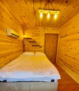 ein Schlafzimmer mit einem Bett in einer Holzhütte in der Unterkunft Trabzon Mountain House-UZUNLU in Trabzon