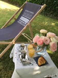 une table avec des fleurs et des tasses et une table avec un sidx de table dans l'établissement Les pommiers, à Honfleur