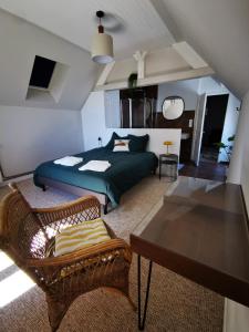 a bedroom with a bed and chairs and a table at La Villégiature in Coutances