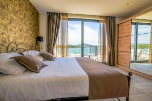 a bedroom with a large bed with a large window at Bonaventura Residence in Murter +64 photos
