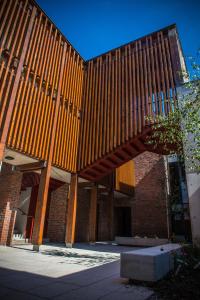 a building with a wooden structure with a bench in front at Neptune's Hostel in Killarney