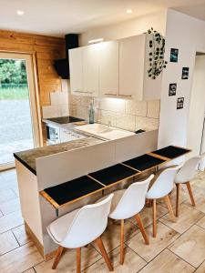 a kitchen with white cabinets and a table and chairs at Chaletdesilles MAYOTTE IIIII in Prat-et-Bonrepaux