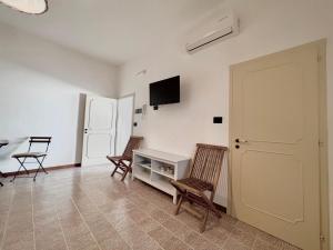 a living room with two chairs and a white table at Monolocale Cora in Corsano