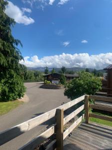 a wooden fence on the side of a road at Feorag Lodge in Aviemore