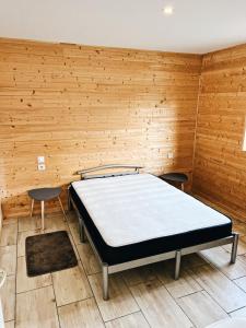 a bed in a room with a wooden wall at Chaletdesilles MAYOTTE IIIII in Prat-et-Bonrepaux