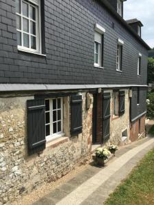 una casa de ladrillo con persianas negras en las ventanas en Les pommiers en Honfleur