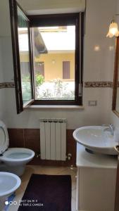 サン・ベネデット・デル・トロントにあるApp con Giardino porticato di uso esclusivo solo per le Famiglieのバスルーム(洗面台、トイレ付)、窓が備わります。