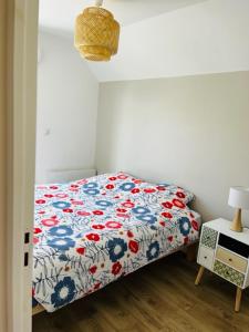 sypialnia z łóżkiem z kołdrą kwiatową w obiekcie La maison des hirondelles w mieście Berck-sur-Mer
