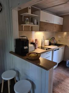 a small kitchen with a counter and stools in it at Little Angel in Warchały