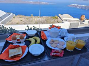 un vassoio di cibo su un tavolo con un vassoio di cibo di Vitsentzos Suites a Imerovigli