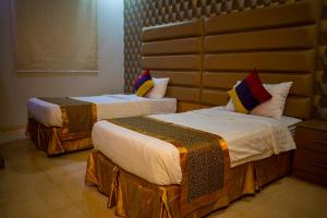 two beds in a hotel room at Ahlin Suites 1 By Khaymat Alyarmouk in Riyadh