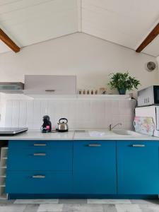 a kitchen with blue cabinets and a sink at Gîte "Dans les Airs", avec piscine chauffée et parking in La Roche-sur-Yon