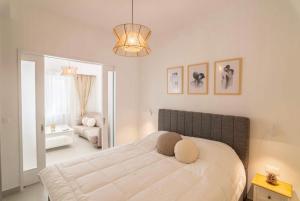 ein Schlafzimmer mit einem großen weißen Bett in einem Zimmer in der Unterkunft Old town luxury apartment in Kos-Stadt