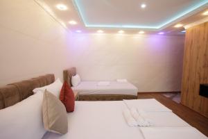 una camera con due letti in una stanza con luci viola di B H B Apartmani a Novi Pazar