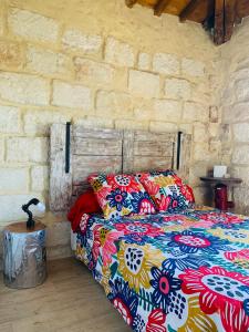 a bedroom with a bed and a brick wall at Lou Mirèio in Aigues-Mortes