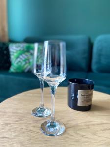 dos copas de vino sentadas sobre una mesa en Apartamenty Termalne GREEN Apartment en Uniejow
