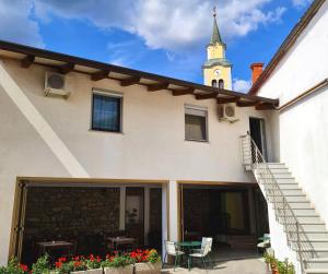 ein Gebäude mit einem Uhrturm und einem Tisch in der Unterkunft Restaurant & Apartments Getaway Pri Kobalu in Vipava