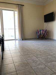 a living room with a tiled floor and a television at Nonika’s House in Tsoukalades