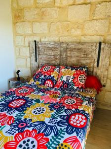 a bed with a colorful comforter in a bedroom at Lou Mirèio in Aigues-Mortes