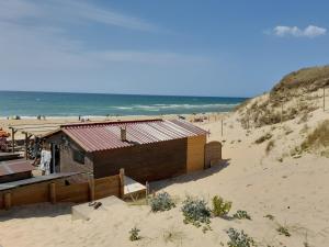 a building on a beach with the ocean in the background at Hope's Land - gîte in Onesse-et-Laharie