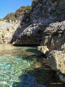 un cuerpo de agua junto a un acantilado rocoso en In Vacanza a Gaeta - MariDea, en Gaeta