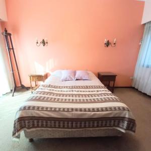 1 dormitorio con 1 cama grande y paredes de color naranja en Del Sol en General Rodríguez