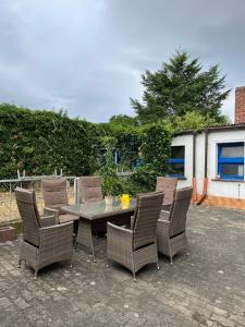 a patio with a table and wicker chairs at Pension Eckert in Zwenkau