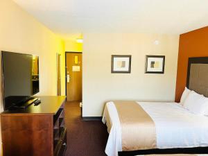 a hotel room with a bed and a desk at Super 8 by Wyndham Fort Scott in Fort Scott