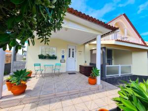 a patio with chairs and a house at Calma do Mar in Madalena