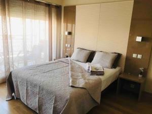sypialnia z dużym łóżkiem i dużym oknem w obiekcie Côte d'Azur joli studio 50m plage, climatisation , parking. w mieście Villeneuve-Loubet