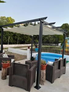 een pergola boven een patio met stoelen en een zwembad bij DEl Rey Guest House in Tomar