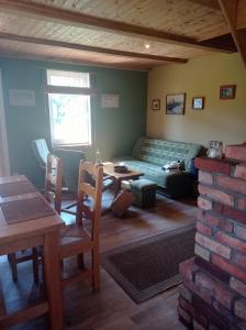 a living room with a couch and a table at Zielona Chatka pod Srebrnym Żurawiem in Wydminy