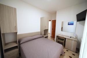 a bedroom with a bed and a desk and a television at Petracuzza casa vacanze in Tortora