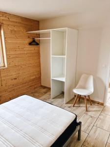 een slaapkamer met een bed en een stoel erin bij chalet des Illes SAINT MARTIN IIII in Prat-et-Bonrepaux