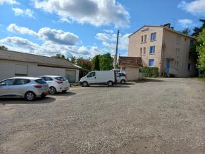 zwei Autos auf einem Parkplatz neben einem Gebäude geparkt in der Unterkunft Le Fréginat - Mauzac in Limoux