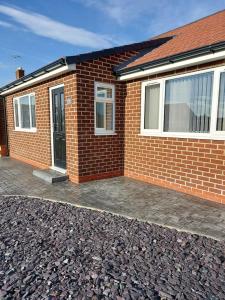 a red brick house with a driveway in front of it at Detached 2 bedroomed bungalow Billingham Stockton on Tees in Stockton-on-Tees