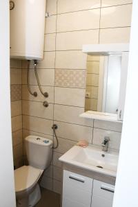 La salle de bains est pourvue de toilettes et d'un lavabo. dans l'établissement Apartment Sarajlic, à Prijedor