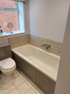 a bathroom with a tub and a toilet and a window at Detached 2 bedroomed bungalow Billingham Stockton on Tees in Stockton-on-Tees