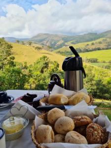 uma mesa coberta com cestas de pão e uma chaleira de chá em Pousada e Hostel Paraíso Capitólio em Capitólio