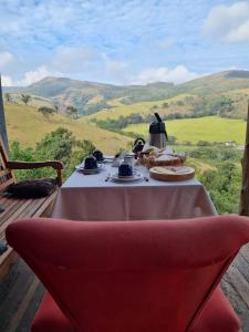 a table with a plate of food and a tea kettle at Pousada e Hostel Paraíso Capitólio in Capitólio