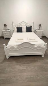 a white bed in a room with two night stands at Castella Aquae II Amplio loft para dos in Merida