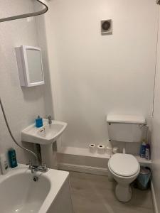 La salle de bains blanche est pourvue de toilettes et d'un lavabo. dans l'établissement Entire Two Bedrooms Flat, 1F, à Great Yarmouth